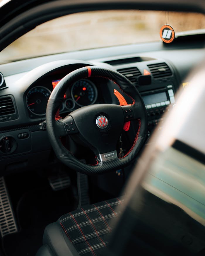 Detailed view of a car interior focusing on a uniquely designed steering wheel with dashboard elements.